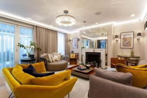 ein Wohnzimmer mit gelben Möbeln und einem Kamin in der Unterkunft Veeve - Lavish and Luxe in London