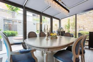ein Esszimmer mit einem Tisch und Stühlen in der Unterkunft Veeve - Lavish and Luxe in London