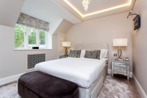 ein Schlafzimmer mit einem großen weißen Bett und einem Fenster in der Unterkunft Veeve - Lavish and Luxe in London