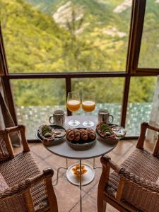 uma mesa com comida e dois copos de sumo de laranja em Carbayu Senda del Oso em Proaza