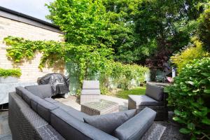 a patio with a couch and a table and chairs at Veeve - Parkland Perfection in London