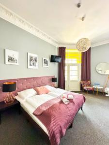 1 dormitorio con 1 cama grande con manta rosa en Expolis Residence - City Center MTP TARGI- Reception 24h, en Poznan