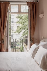 a bedroom with a bed and a large window at Veeve - Poetic Harmony in Paris