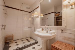 uma casa de banho branca com um lavatório e um chuveiro em Veeve - Palatial Grandeur em Paris