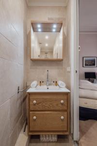 uma casa de banho com um lavatório, um espelho e uma cama em Veeve - Palatial Grandeur em Paris