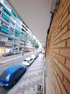 a street with cars parked on the side of a building at Apartamento 50mt Playa Cullera (San Antonio) in Cullera