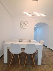 una mesa blanca con 4 sillas en una habitación en Apartamento 50mt Playa Cullera (San Antonio) en Cullera