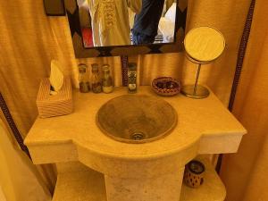 a sink in a bathroom with a mirror at Arena Desert Camp & Activitys in Merzouga
