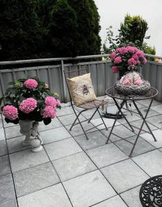 a patio with a table and chairs and flowers at Ferienwohnung und Appartement nähe Möhnesee für 4 Personen in Warstein
