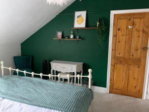 - une chambre avec un lit et un mur vert dans l'établissement Trendy Westbourne Flat, à Bournemouth