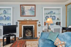 a living room with a blue couch and a fireplace at Veeve - Mews & Blues in London