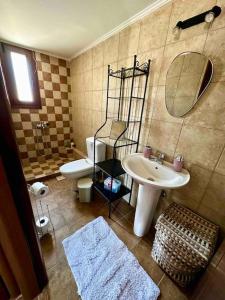 a bathroom with a sink and a toilet and a mirror at Cliffside Cozy Villa w/ Seaviews in Mézapos