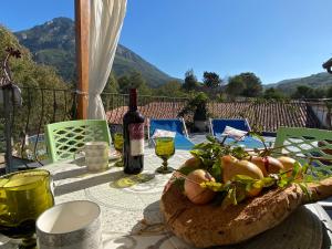stół z talerzem jedzenia i butelką wina w obiekcie Taddore Green Lodge w mieście Galtellì