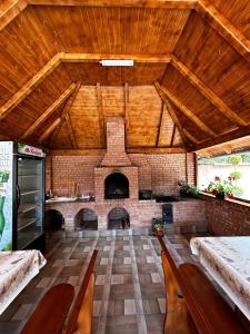 una gran sala de estar con una gran chimenea de ladrillo en Casa Larisa, en Chişcău