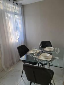 a dining room with a glass table and chairs at Pousada Calma in Maputo