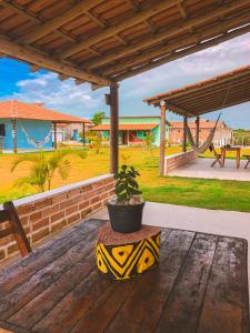 a potted plant sitting on a wooden table on a porch at Pousada Villa Esperança - Xandó - Caraíva BA in Caraíva