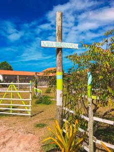 um sinal de rua num poste de madeira com uma cerca em Pousada Villa Esperança - Xandó - Caraíva BA em Caraíva