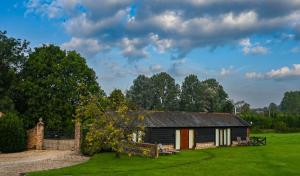 an old house in the middle of a field at The Tool Shed in Wimborne Minster