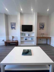 a living room with a white table and a tv at Beautiful flat in city centre in Brighton & Hove