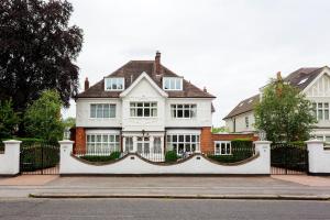 een wit huis met een hek ervoor bij Veeve - Courtside Dreams in Londen
