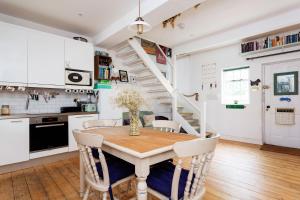 a kitchen and dining room with a table and a staircase at Veeve - Harmonious Hideaway in London