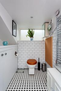 a bathroom with a toilet with a tiled floor at Veeve - Harmonious Hideaway in London