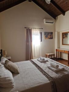 una camera da letto con un letto con due asciugamani sopra di Villa Penelope a Douliana