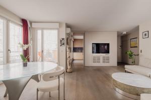 een woonkamer met een tafel en een bank bij Veeve - Belle Blanche in Parijs
