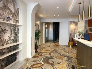 um corredor com piso em azulejo no átrio do hotel em Timhotel Palais Royal em Paris