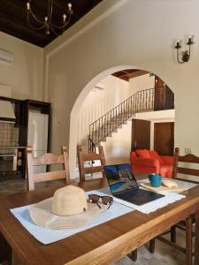 a table with a hat and a laptop on it at Villa Penelope Luxury Retreat with Pool & Timeless Charm in Douliana +105 photos