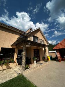 a house with a balcony on top of it at Casa Larisa in Chişcău