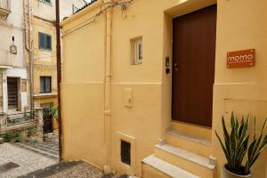 Una puerta de un edificio con un cartel que dice morgue en Momoflat, en Agrigento