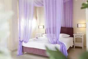 a bedroom with purple curtains and a bed at Sunny Hill in Sani Beach