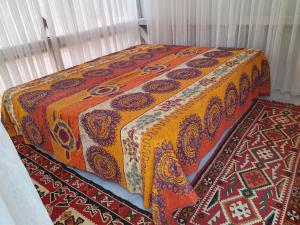 a bed with a colorful blanket and a rug at Exotic sleeping in the woods near Olbia in Telti
