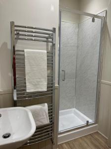 a bathroom with a shower and a sink and a tub at The Victoria Hotel,Bar,Bistro in Norham