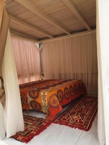 a bed in a room with two rugs on the floor at Exotic sleeping in the woods near Olbia in Telti