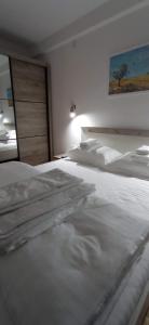 a bedroom with two white beds and a painting on the wall at Planinska idila in Kopaonik +23 photos
