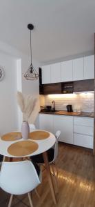 a kitchen with a table and chairs and a kitchen with white cabinets at Planinska idila in Kopaonik