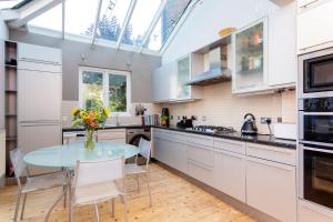a kitchen with a table and chairs and a window at Veeve - Blissful Oasis in London