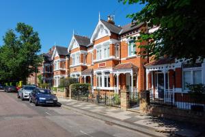 a row of houses with cars parked on a street at Veeve - Blissful Oasis in London