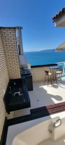 a balcony with a sink and a view of the ocean at Cobertura Duplex Vista Mar in Mangaratiba