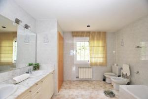 baño con 2 lavabos, aseo y ventana en Sunny house, en Cabrils