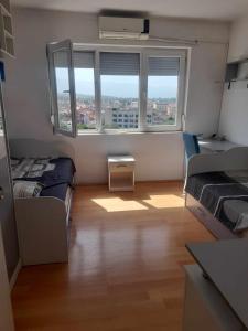 um pequeno quarto com 2 camas e uma janela em CENTAR em Kumanovo