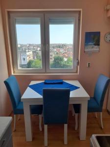 a dining room table with chairs and two windows at CENTAR in Kumanovo