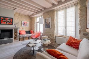 een woonkamer met een witte bank en een open haard bij Veeve - Artistic Flamboyance in Boulogne-Billancourt