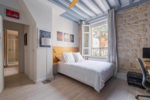 een slaapkamer met een bed en een stenen muur bij Veeve - Artistic Flamboyance in Boulogne-Billancourt