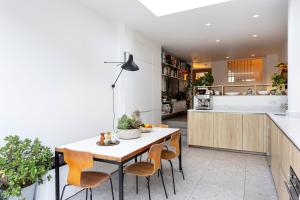 uma cozinha com mesa e cadeiras num quarto em Veeve - Visual Virtuosity em Londres