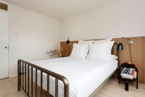 um quarto com uma cama grande e lençóis brancos em Veeve - Visual Virtuosity em Londres