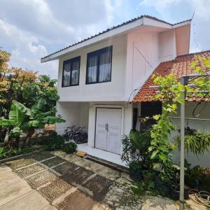 una casa con una puerta blanca y algunas plantas en Coral House - Near Univ Indonesia Setu Babakan, en Yakarta