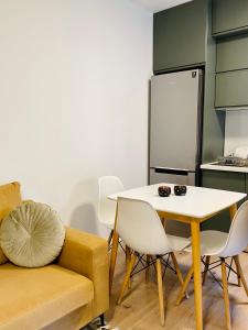 uma sala de estar com uma mesa e um sofá e uma cozinha em Jolie Center Apartment em Tirana